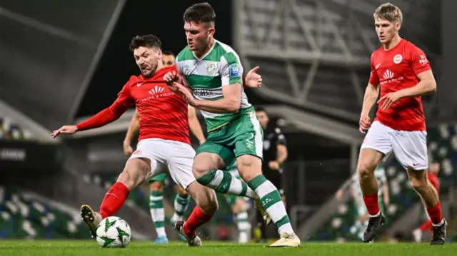 Larne defender Tomas Cosgrove challenges Josh Honohan at Windsor Park