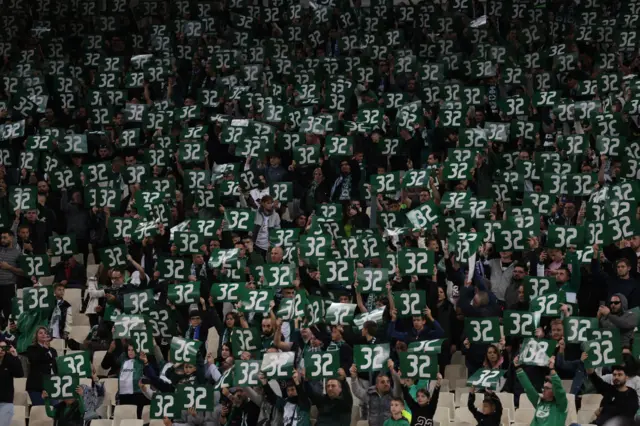 Panathinaikos fans hold up the number 32 in Baldock's memory