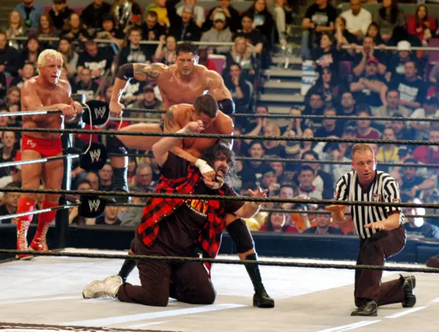 Ric Flair, Batista, Randy Orton and Mick Foley in a wrestling ring at Wrestle Mania XX