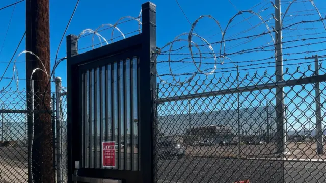 A gate and fence with barbed wire