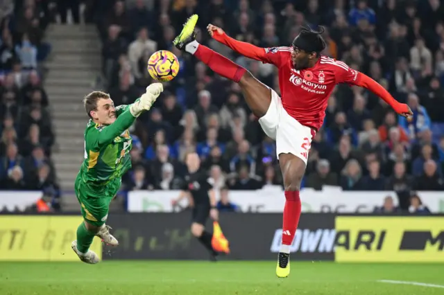 Mads Hermansen of Leicester City punches the ball clear from Anthony Elanga