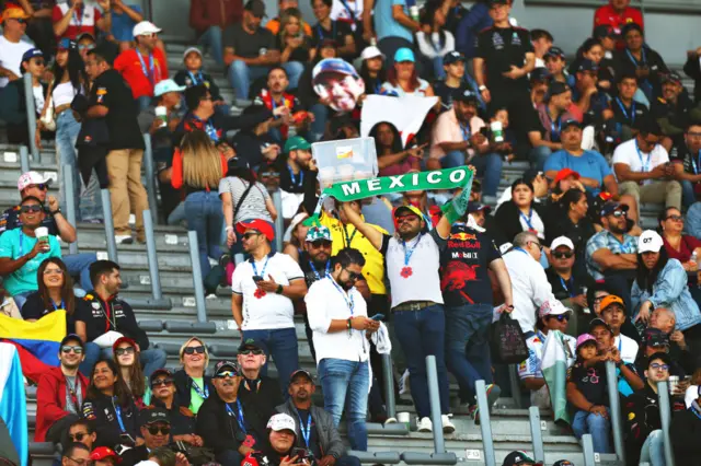 Fans hold up a Mexico scarf