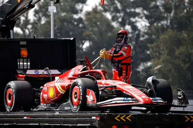 A marshal puts Oliver Bearman's Ferrari on to the recovery truck