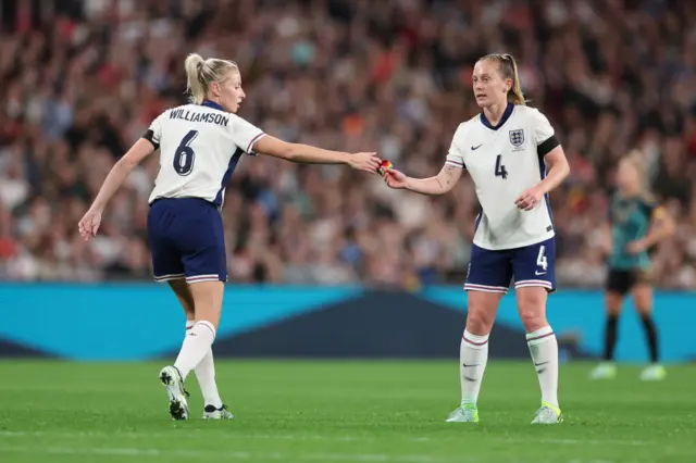 Leah Williamson handing captain armband to Keira Walsh