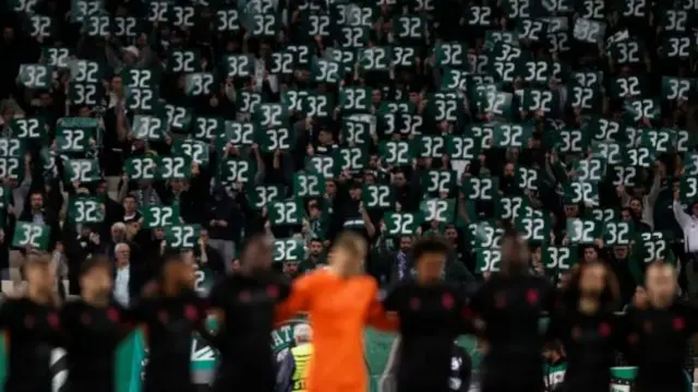 Panathinaikos fans hold aloft banners bearing George Baldock's squad number