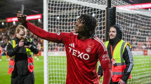 ABERDEEN, SCOTLAND - OCTOBER 26: Aberdeen's Peter Ambrose takes a picture with the fans at full time during a William Hill Premiership match between Aberdeen and Dundee United at Pittodrie Stadium, on October 26, 2024, in Aberdeen, Scotland. (Photo by Alan Harvey / SNS Group)