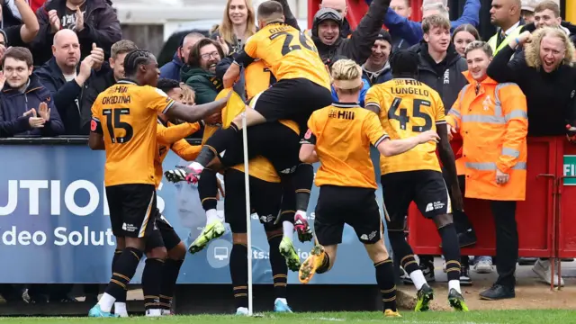 Cambridge players mob goalscorer Jordan Cousins.