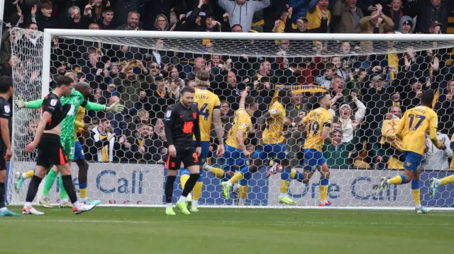 Mansfield players celebrate behind the goal after Lee Gregory's equaliser.