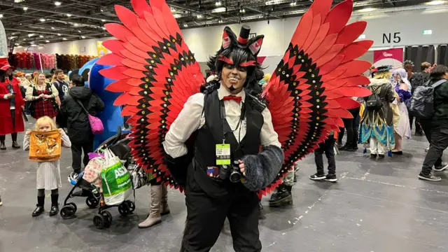 A person adorned with wings featuring tiny pieces of felt and gems