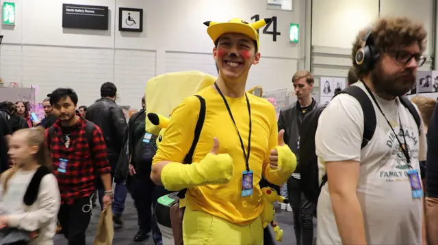 A person dressed as a Pikachu with their thumb up