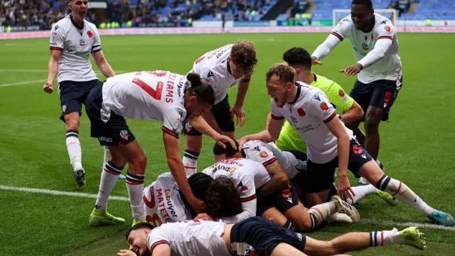 Bolton players are delirious as they celebrate Klaidi Lolos' late winner.