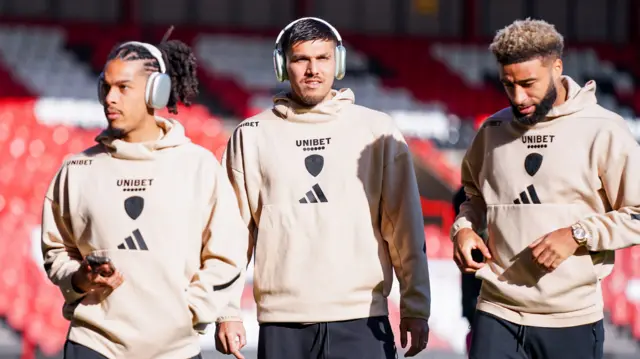 Three Leeds United players wearing tracksuits