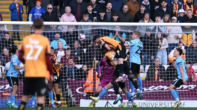 Bradford's Andy Cook rises to connect with a header.