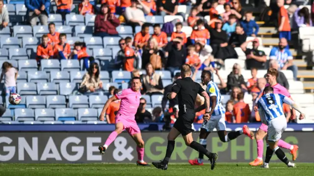 Ben Wiles scores Huddersfield's second against Exeter.