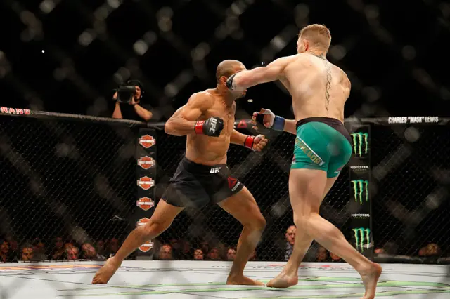 Conor McGregor hits Jose Aldo with a left hook