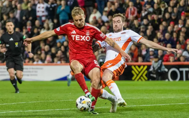 ABERDEEN, SCOTLAND - OCTOBER 26: Aberdeen's Topi Keskinen and Dundee United's Kevin Holt in action during a William Hill Premiership match between Aberdeen and Dundee United at Pittodrie Stadium, on October 26, 2024, in Aberdeen, Scotland. (Photo by Alan Harvey / SNS Group)