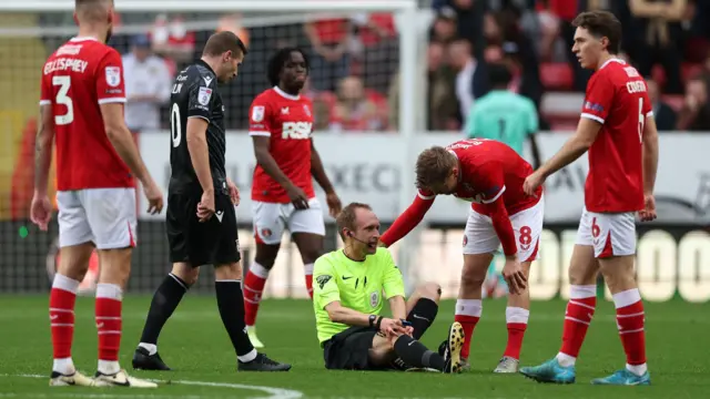 Referee Sam Purkiss goes down with an injury.