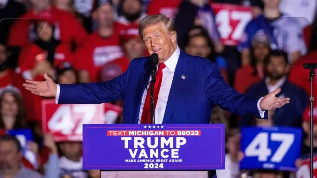 Donald Trump gestures on stage