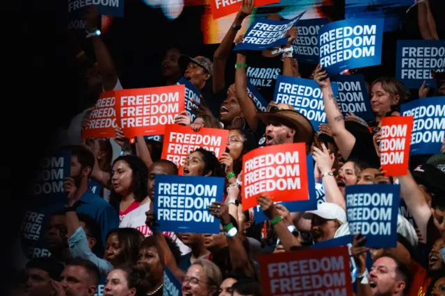 Harris supporters wave red and blue signs that read Freedom