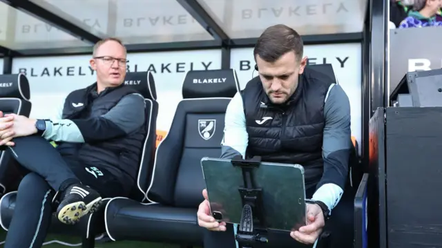 Norwich coach Jack Wilshere inspects a laptop