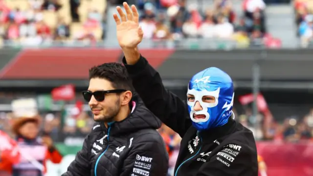 Pierre Gasly and Esteban Ocon wave to the crowd during the drivers parade