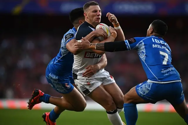 England's George Williams (C) is tackled during the 2021 rugby league World Cup