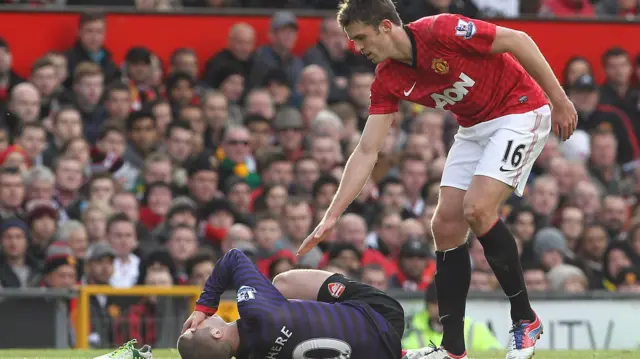 Michael Carrick checks an injured Jack Wilshere