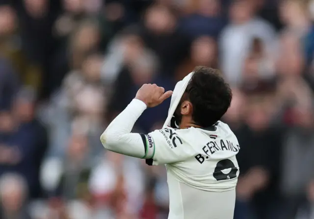 Fernandes covers his face with his shirt