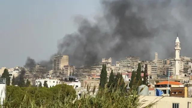 Smokes rises from an area that appears to be densely packed with buildings