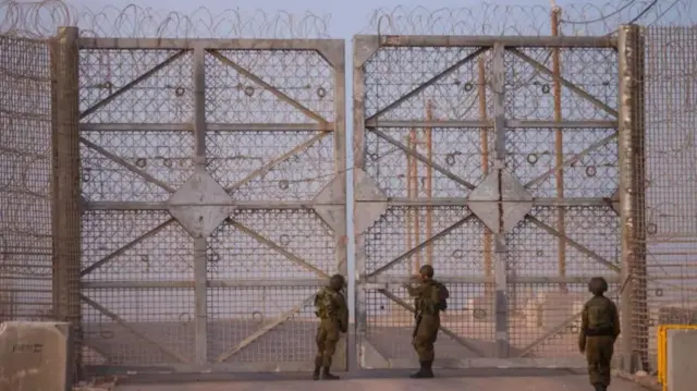 Israeli soldiers check a gate as they patrol along the Israel-Gaza border area on October 21, 2024, amid the ongoing war between Israel and the Hamas militant group.