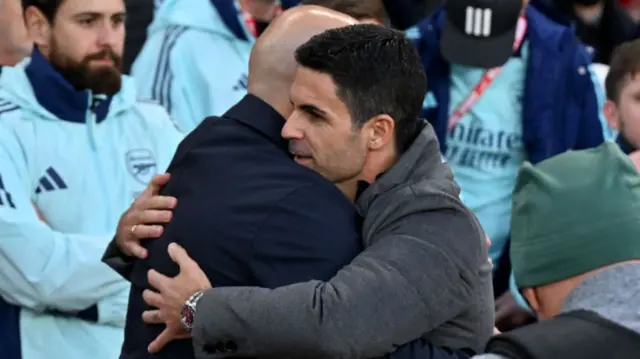 Arne Slot head coach of Liverpool embracing Mikel Arteta manager of Arsenal