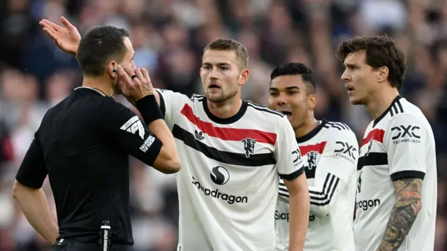 Manchester United players protest to referee David Coote during their defeat at West Ham