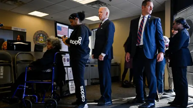 Joe Biden waits in line to vote