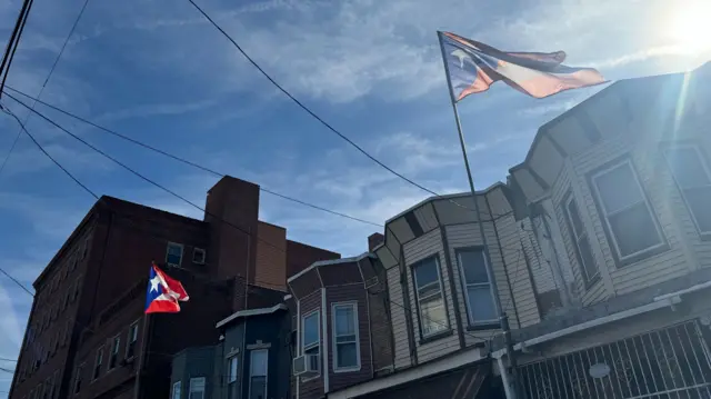 Puerto Rican flags fly in the sun on buildings in Philadelphia