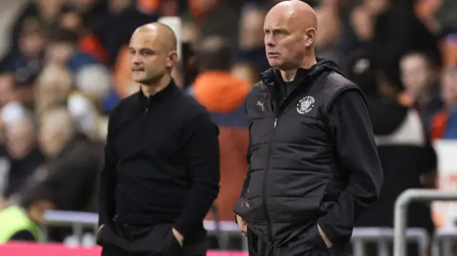 Wigan manager Shaun Maloney and Blackpool assistant Steve Agnew watch on.