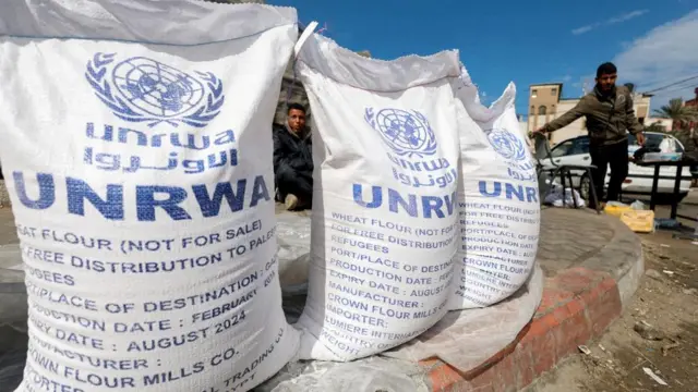 Displaced Palestinians wait to receive United Nations Relief and Works Agency (UNRWA) aid, amid the ongoing conflict between Israel and the Palestinian Islamist group Hamas, in Rafah