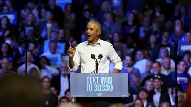 Barack Obama speaking before supporters of Harris at a rally in Philadelphia, Pennsylvania before a podium.