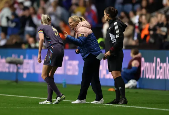 Leah Williamson getting instructions from Sarina Wiegman