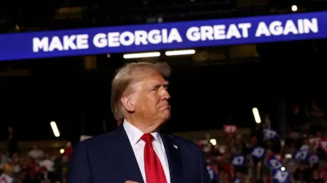 Trump at his rally in Georgia stood under a sign that says "make Georgia great again"