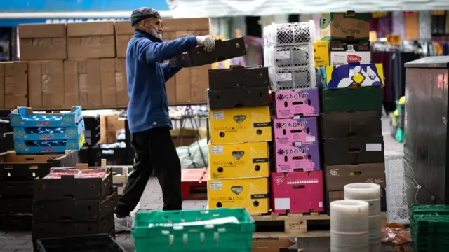 A worker stacks his stock at Walthamstow Market in east London