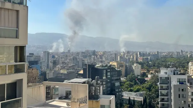 An image showing smoke rising from tower blocks in a city