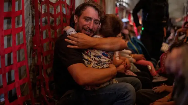 Man hugs child on plane