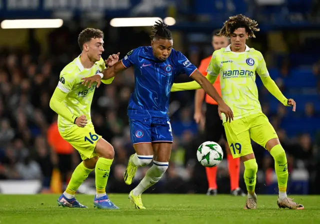 Chelsea's Christopher Nkunku in action with Gent's Mathias Delorge-Knieper and Gent's Franck Surdez