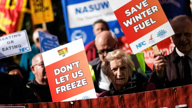 Protesters hold placards saying "don't let us freeze" and "save winter fuel" in London, 7 October 2024