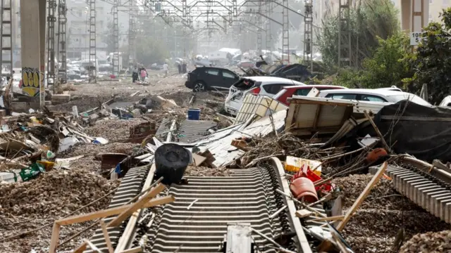 Damaged cars lie amidst debris along damaged rail lines in the flood-hit city of Valencia