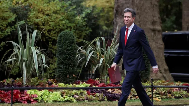 Ed Miliband smiles to camera as he walks up Downing Street