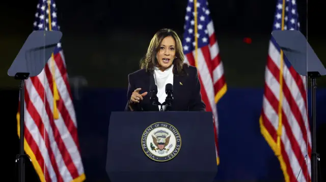 Harris makes her speech at a lectern with US flags either side