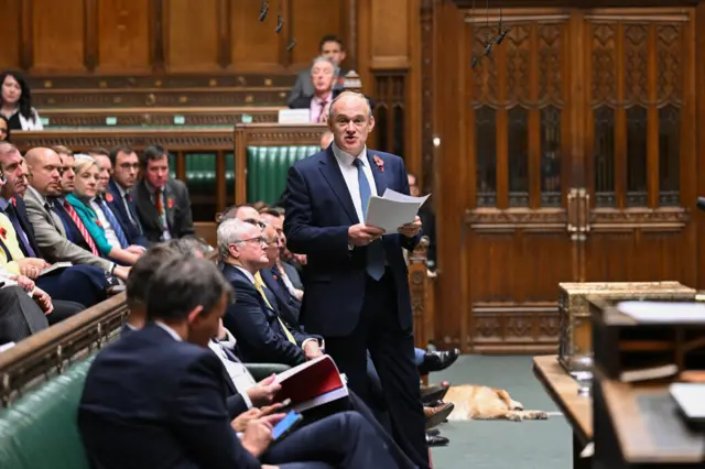 Ed Davey stood up in the House of Commons in front of MPs who look at him as he speaks