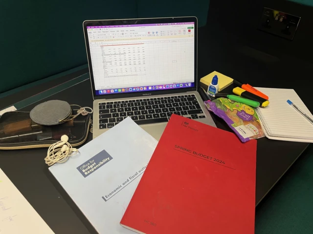 A laptop, a notebook and folders on a desk