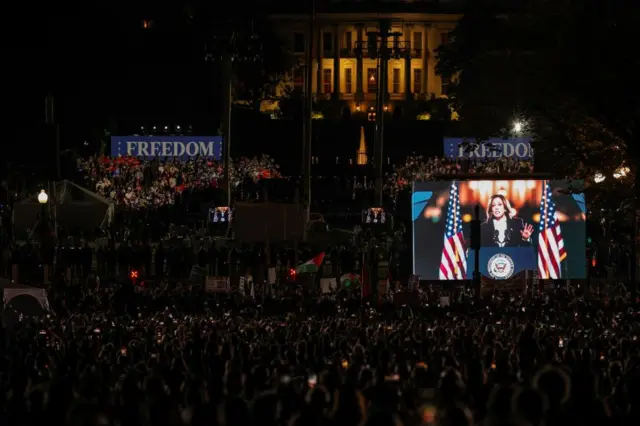 Democratic presidential nominee U.S. Vice President Kamala Harris is displayed on a screen as she delivers a speech to crowds